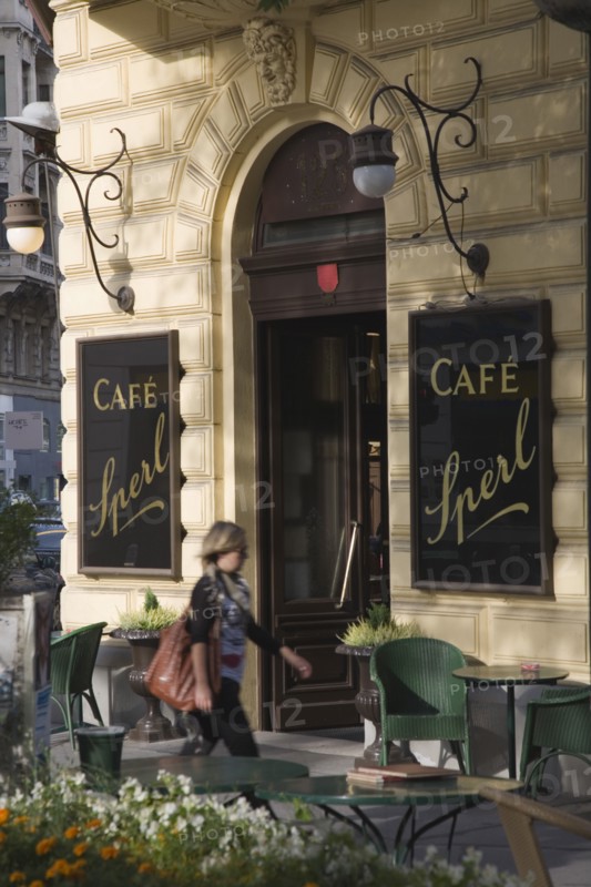 Vienna, Austria. Mariahilf District Cafe Sperl the preferred cafe of Adolf Hitler. Exterior with empty outside tables and woman walking past entrance. Established for over 120 years the cafe offers billiards and forbids mobile phones. Austria Asutrian Vienna Viennese Mariahlf 6th District Cafe Sperl Hitler Waitress Entrance Coffee Exterior Europe European Work Urban City Table Tables Schanigarten Austrian Bar Bistro Cell Cellular Destination Destinations Female Women Girl Lady History Historic One individual Solo Lone Solitary Osterreich Restaurant Viena Western Europe Wien