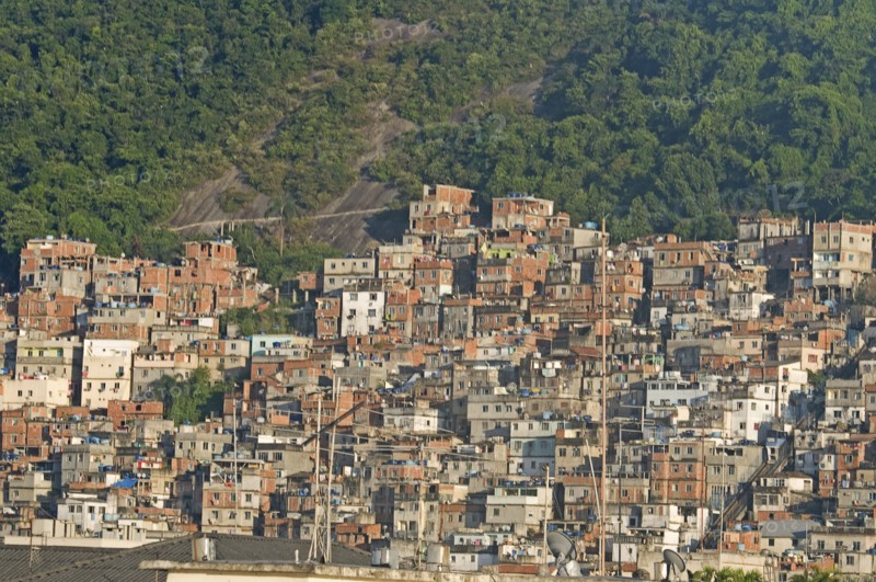 Rio de Janeiro, Brazil. Favela or slum on hillside above Copacabana neighbourhood steep road through slum rock face and tree cover with antenna in foreground. Brazil Brasil Brazilian Brasilian South America Latin Latino American City Urban Architecture Houses Housing Homes Copacabana Neighborhood Neighbourhood Favela Favelas Slum Slums Church Rio de Janeiro Aerial Destination Destinations Latin America Shanty South America Southern