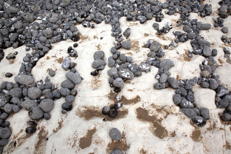 Birling Gap, East Sussex, England. Pebbles of various sizes deposited on chalk shelf by the sea. England English UK United Kingdom GB Great Britain Birtish East Sussex County Birling Gap Eastbourne Sea Coast Chalk Cliff Cliffs White Pebbles Sea Deposit Deposited Erosion Water Pattern Stone Stones Pebble