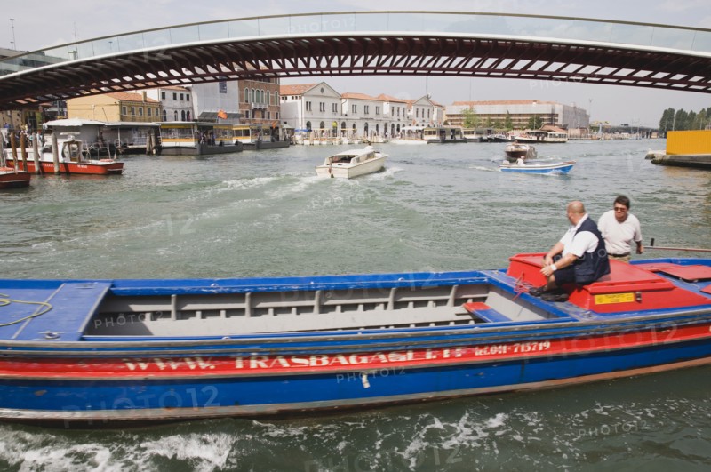 Venice, Veneto, Italy. Ponte di Calatrava Bridge Fourth bridge across the Grand Canal opened in September 2008 linking the train station and Piazzale by Spanish architect Santiago Calatrava. Red and blue painted working canal boat passing in foreground. Italy Italia Italian Venice Veneto Venezia Europe European City Grand Canal Fourth Bridge Transport Water Architecture Di Calatrava Ponte Bridge Fourth Canal Grand Boat Boats Barge Destination Destinations Southern Europe