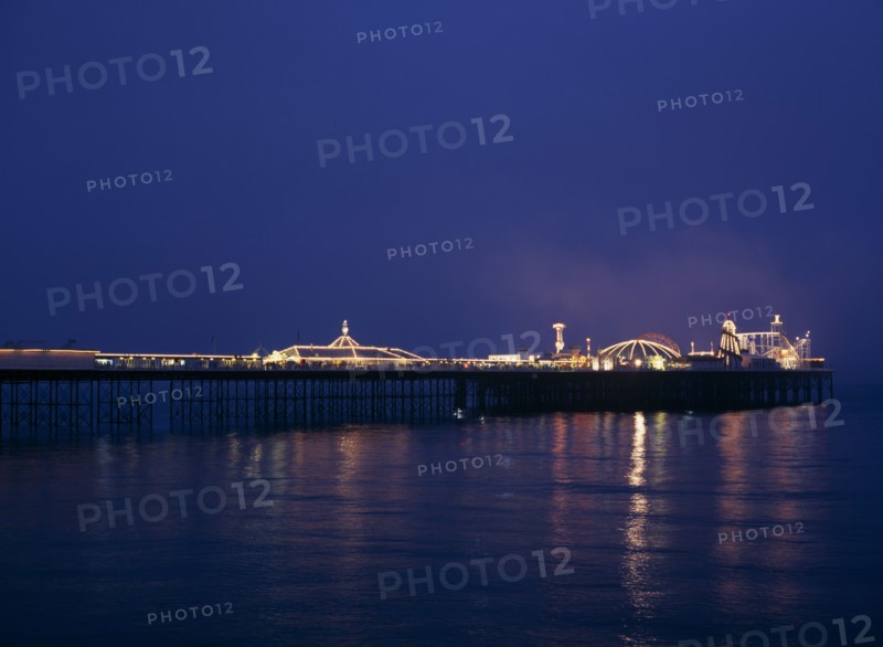 Brighton, East Sussex, England. Brighton Pier illuminated at night European Great Britain Nite Northern Europe UK United Kingdom