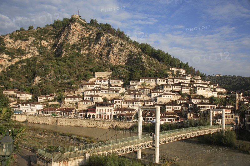 Albania, Berat, Traditional Ottoman buildings across hillside overlooking footbridge over the River Osum.
