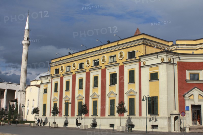 Albania, Tirane, Tirana, Exterior facade of government buildings beside Ethem Bey Mosque and minaret on Skanderbeg Square.