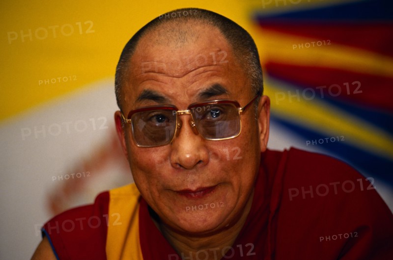 China, Tibet, Buddhism, Portrait of the 14th Dalai Lama. Tibetan Buddhist Leader in exile. Vibrant image of a yellow sun in the background.