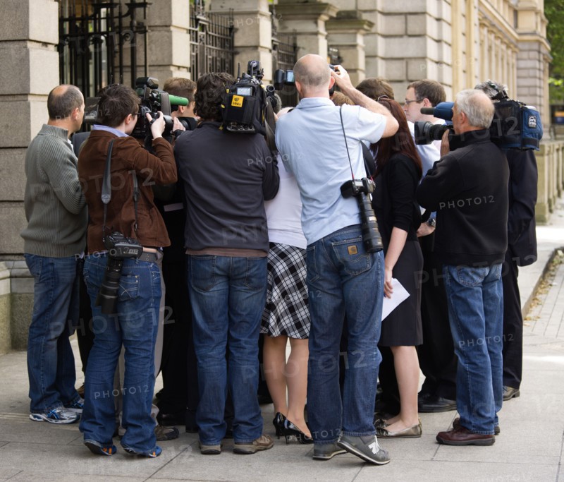 Ireland, County Dublin, Dublin City, News Media Press photographers cameramen and journalists surrounding a politician on the pavement sidewalk outside the Irish Parliament buildings.