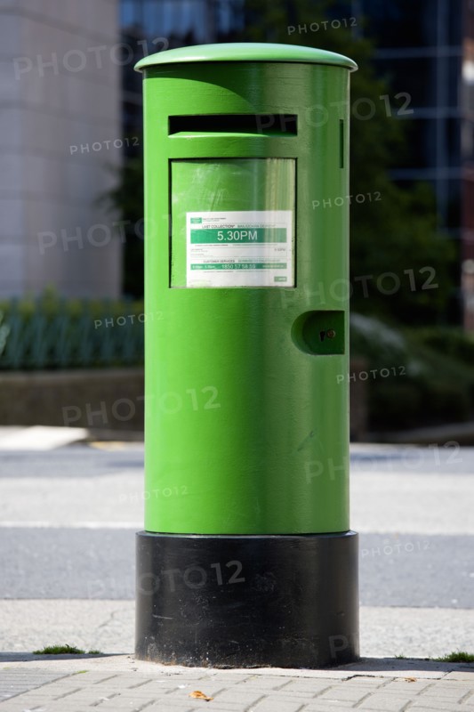 Ireland, County Dublin, Dublin City, A traditional old fashioned green letterbox on the pavement sidewalk.