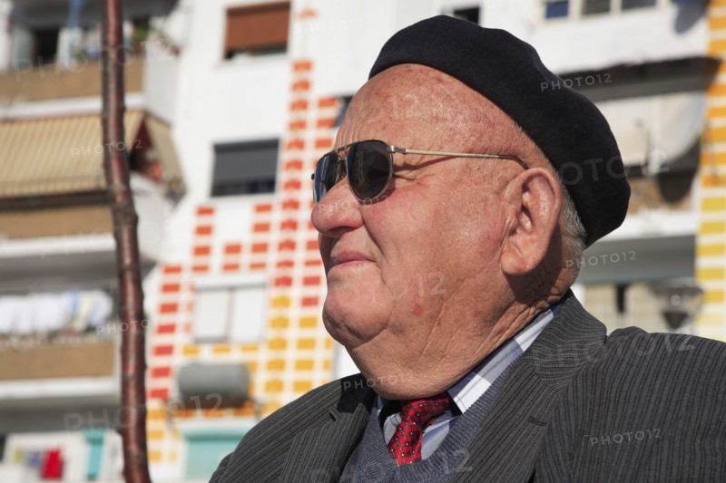Albania, Tirane, Tirana, Head and shoulders portrait of an elderly man wearing sunglasses and a beret. Profile left.