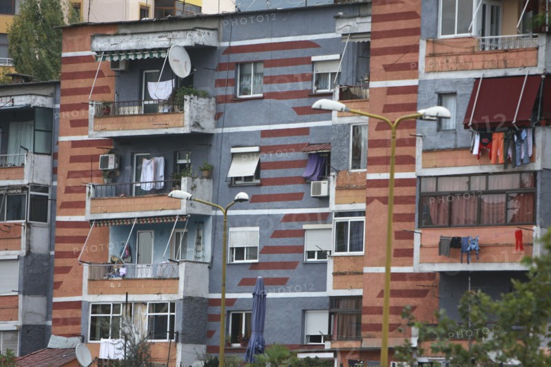 Albania, Tirane, Tirana, Part view of exterior facade of colourful apartment building with washing hanging on the balconies.