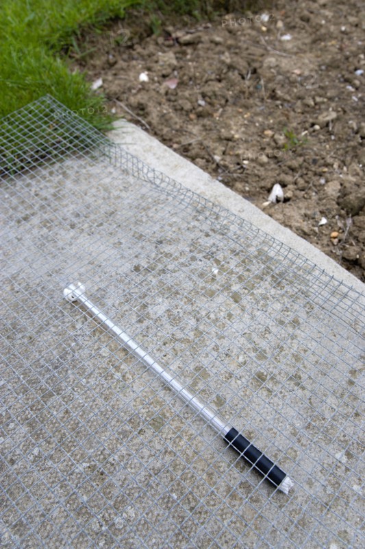 Climate, Weather, Measurements, Thermometer beneath protective wire mesh laid on concrete to measure the minimum overnight concrete temperature beside patch of clear earth where the moisture content of the earth is observed at the Bognor Regis weather sta