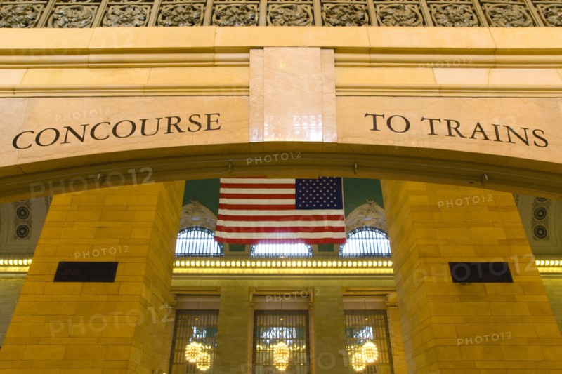 USA, New York, New York City, Manhattan  Grand Central Terminal railway station entrance to the Main Concourse from the Vanderbilt Hall with the American Stars and Stripes flag hanging from the ceiling.
