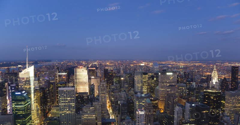 USA, New York, New York City, Manhattan  View from Empire State building over midtown skyscrapers with Art Deco Chrysler Building illuminated at sunset.