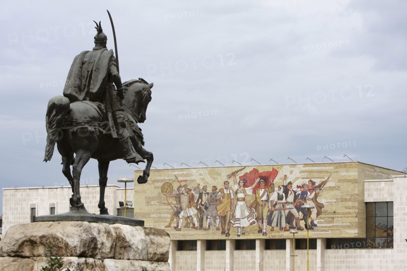 Albania, Tirane, Tirana, Equestrian statue of George Castriot Skanderbeg in Skanderbeg Square with the National History Museum exterior facade and mural beyond.