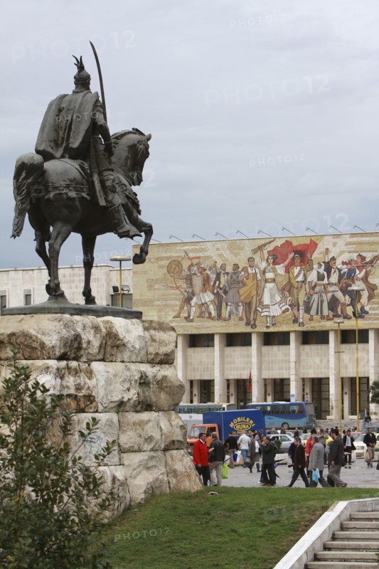 Albania, Tirane, Tirana, Equestrian statue of George Castriot Skanderbeg in busy Skanderbeg Square with the National History Museum exterior facade and mural beyond.