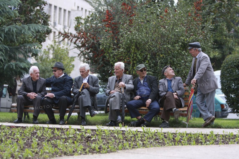 Albania, Tirane, Tirana, Group of elderly men and pensioners talking on a park bench.