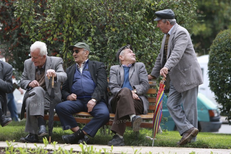 Albania, Tirane, Tirana, Group of elderly men and pensioners talking on a park bench.