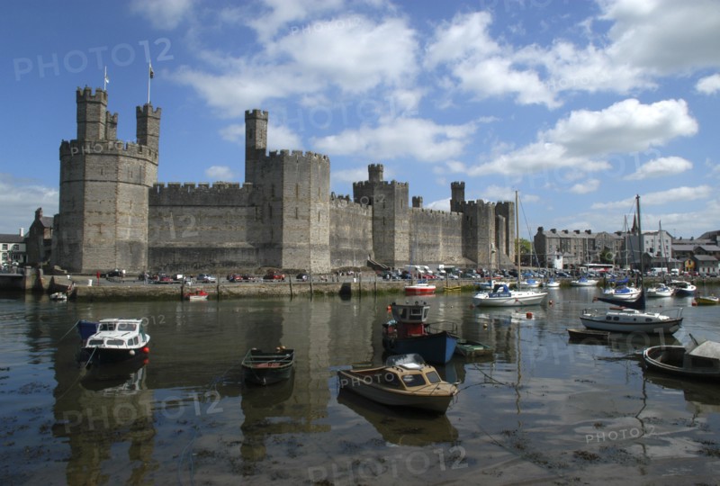 Wales, Gwynedd, Conway, Conway Castle seen over moored boats in the harbour