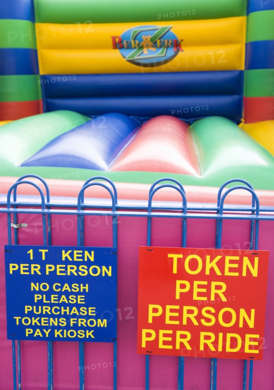 England, West Sussex, Bognor Regis, Empty colourful bouncy castle with signs on the Esplanade beside the beach.