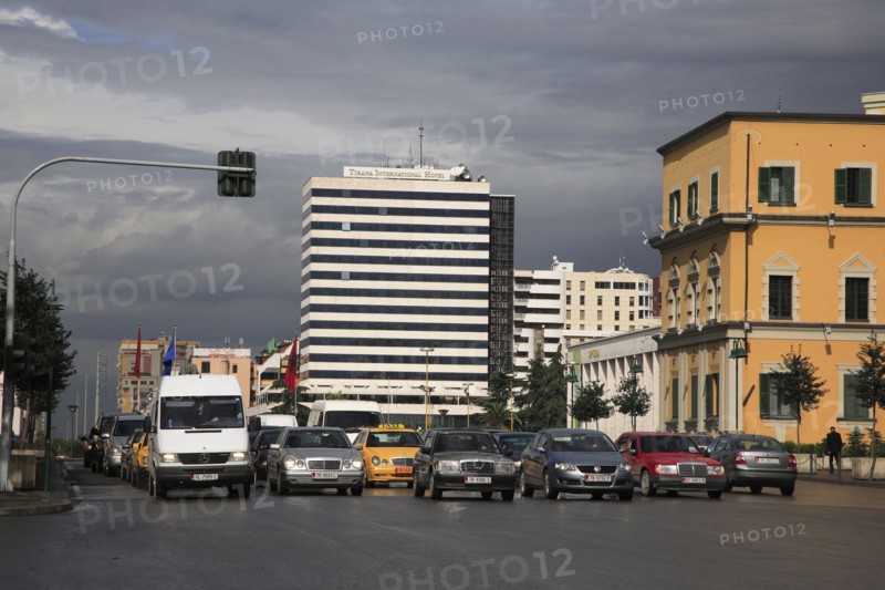 Albania, Tirane, Tirana, Traffic waiting at lights in Skanderbeg Square in front of the Tirana International Hotel.