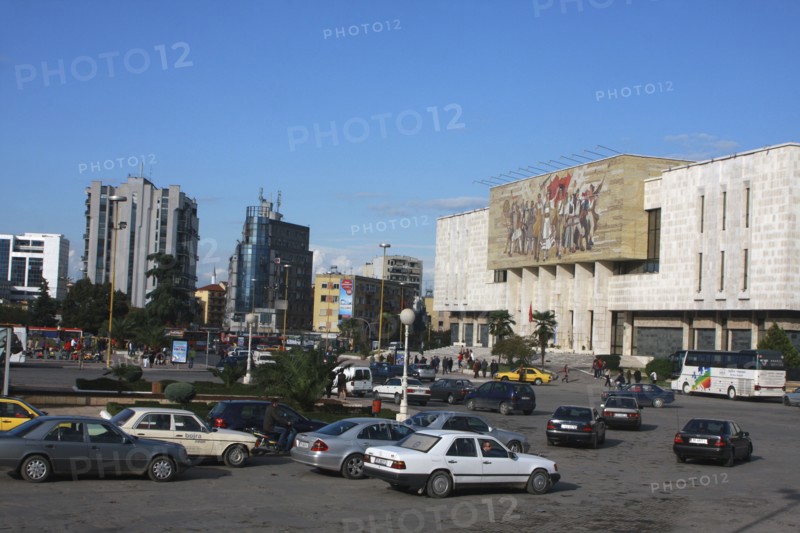 Albania, Tirane, Tirana, Traffic in Skanderbeg Square passing exterior facade of the National History Museum to the right.