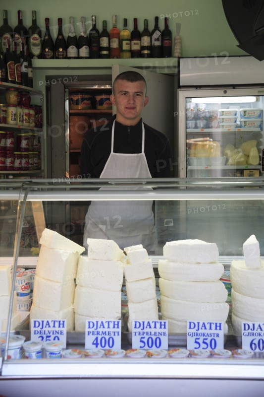 Albania, Tirane, Tirana, Cheese shop with young male vendor standing behind counter in the Avni Rustemi Market.