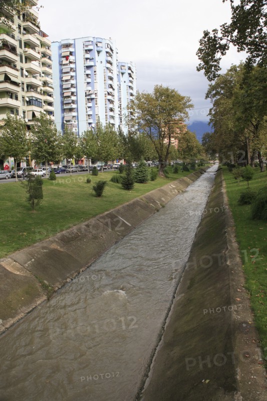 Albania, Tirane, Tirana, River Lana running past apartment blocks.