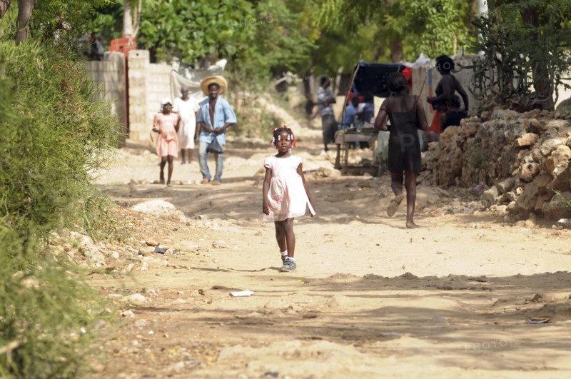 Haiti, La Gonave, Young girl walking along dirt track.