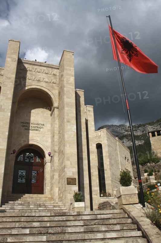 Albania, Kruja, Kruja Castle and Skanderbeg Museum  exterior facade with steps to entrance and National flag raised on flagpole at side.
