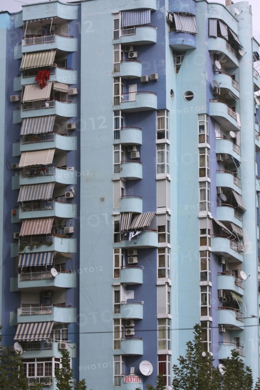 Albania, Tirane, Tirana, Balconies and striped awnings on blue painted exterior facade of multi storey apartment block.