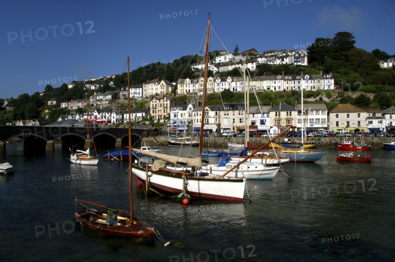 England, Cornwall, Looe, View over moored boats and bridge with waterfront architecture beyond