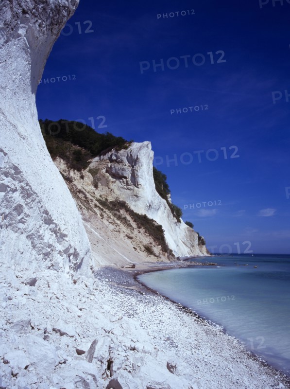Denmark, Isle of Mon, Mons Klint, East facing chalk sea cliffs with flintstone beach.  Blue sky with high windswept clouds above.