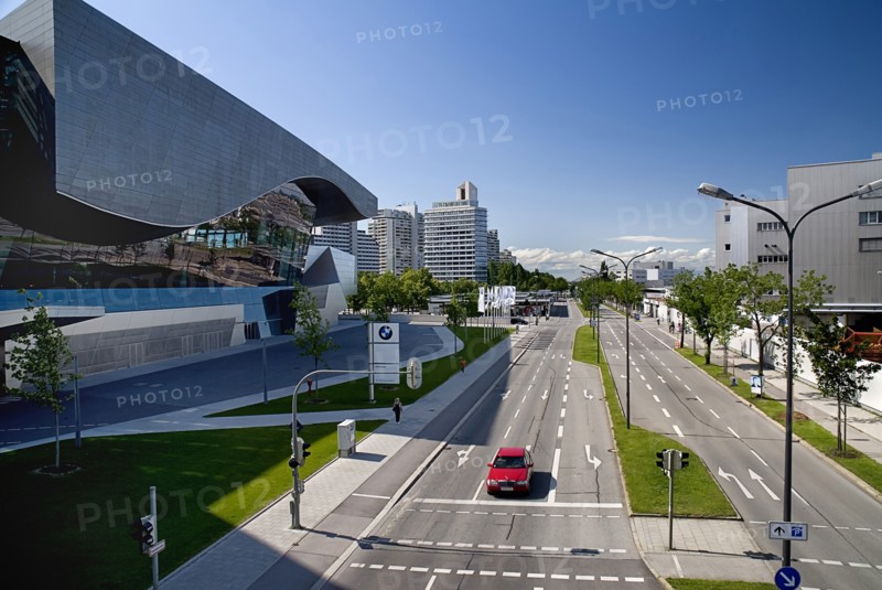 BMW Welt showroom on left hand side opposite the head-quarters building with car on multi-lane road in foreground. Photo: Hugh Rooney