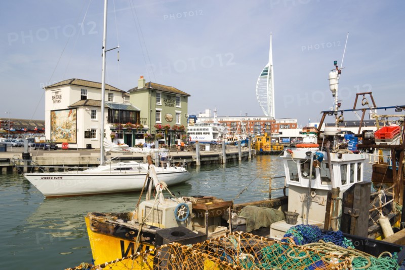 The Camber in Old Portsmouth showing the Spinnaker Tower behind the Bridge Tavern with its mural of Thomas Rowlansons cartoon titled Portsmouth Point and fishing boats moored along the quayside. Photo : Paul Seheult
