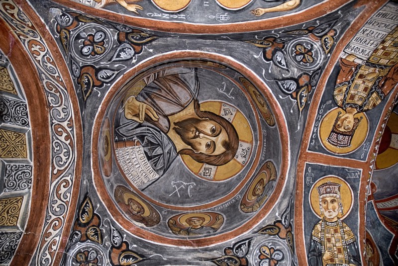 Open Air Museum. The Dark Church so named because it had few windows. Detail of fresco dating from the eleventh century depicting Christ as Pantocrator holding book of gospels in his left hand and making sign of blessing with his right. Photo : Hugh Rooney