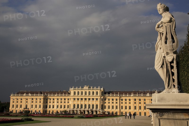 Schonnbrunn Palace. Exterior with statue of standing figure in foreground beneath grey stormy sky. Photo : Bennett Dean