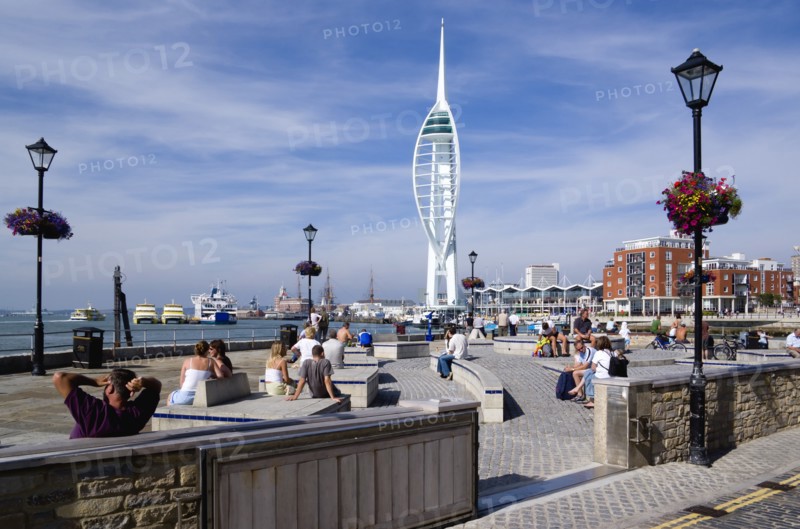 The 170 metre tall Spinnaker Tower and Historic naval Dockyard seen from Bath Square on Spice Island in Old Portsmouth with people seated in the foreground. Photo: Paul Seheult
