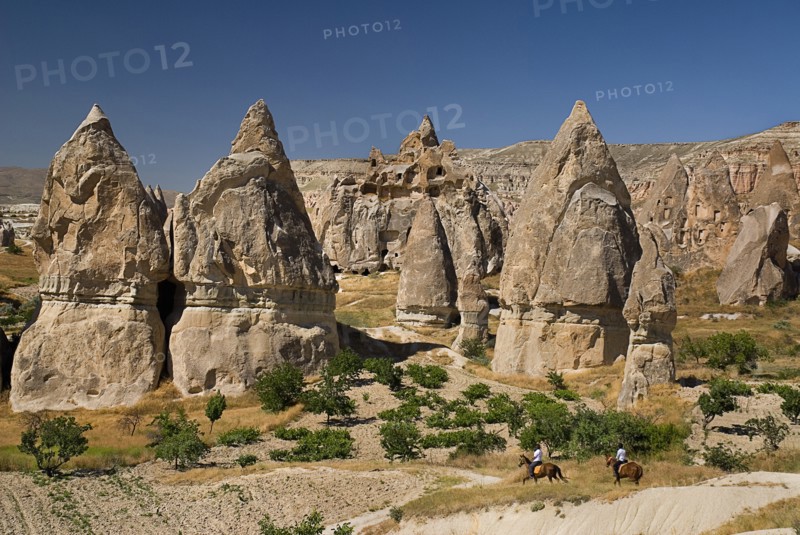 Sword Valley rock formations with horse riders in foreground. The valley got its name because of the appearance of sharpness to the pinnacles found there. Photo: Hugh Rooney