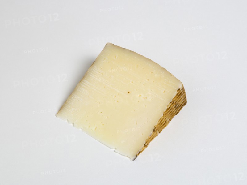 Slice of Spanish Manchego cheese made from pasteurised Manchega sheeps milk from the La Mancha region of Spain against a white background. Photo : Paul Seheult