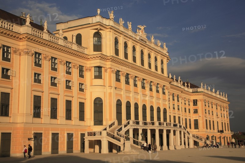 Schonnbrunn Palace. Part view of exterior facade with tourist visitors in courtyard in foreground. Photo: Bennett Dean