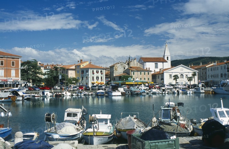 Port with fishing boats. Cars parked around the edge. Photo: Jonas Grau