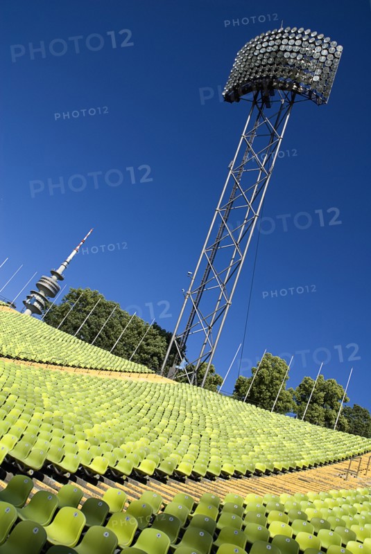 Olympic Stadium. Angled view across green seating of the stadium with floodlight and part view of the Olympic Tower behind. Photo: Hugh Rooney