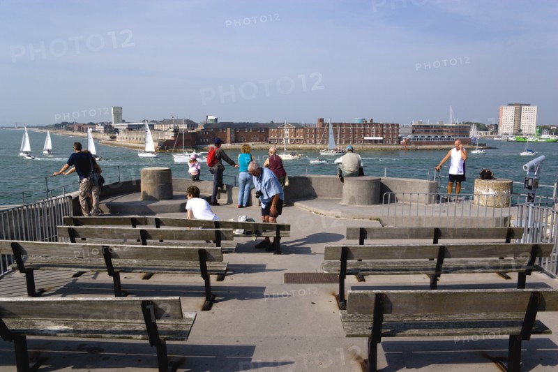 Tourists and seats on the top of The Round Tower in Old Portsmouth and yachts passing through the entrance to the harbour with HMS Dolphin in Gosport on the far side. Photo : Paul Seheult