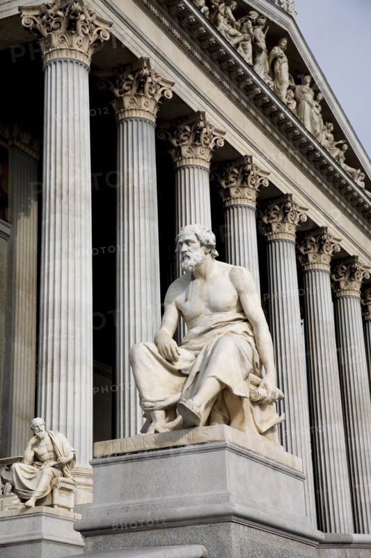 Part view of colonnaded exterior of the Parliament building with statue of the Greek philosopher Thucydides in foreground. Photo: Bennett Dean