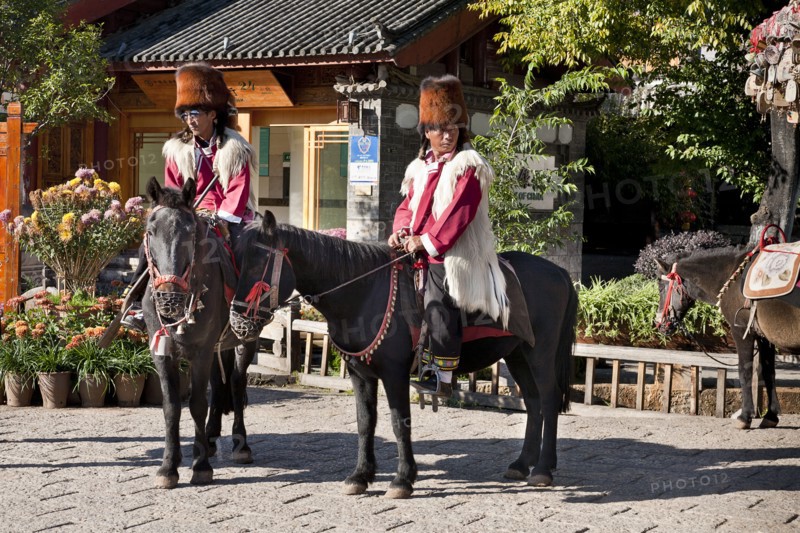 Naxi men on horseback wearing traditional costume including Red panda skin hats. Photo : Mel Longhurst
