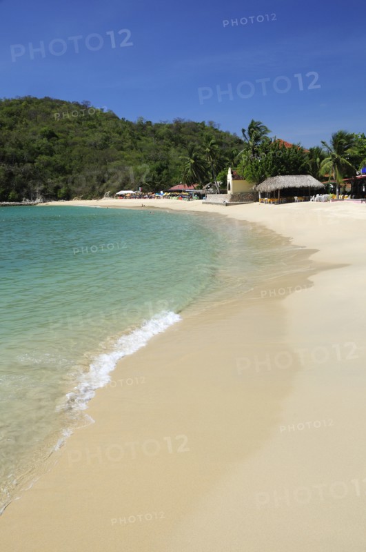 Mexico, Oaxaca, Huatulco, Bahia Santa Cruz View along stretch of sandy beach lined by restaurants and other buildings. 
Photo : Nick Bonetti