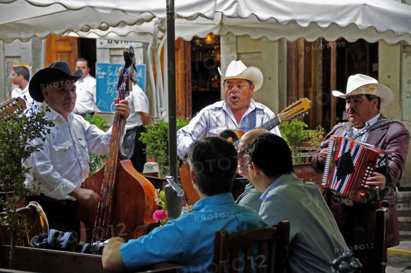 Mexico, Bajio, Guanajuato, Mariachi musicians playing at cafe in Jardin de la Union. 
Photo : Nick Bonetti