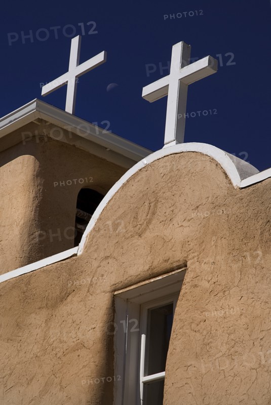 USA, New Mexico, Taos, Church of San Francisco de Asis. Detail of adobe style exterior architectecture and white painted crosses on rooftop. 
Photo : Hugh Rooney