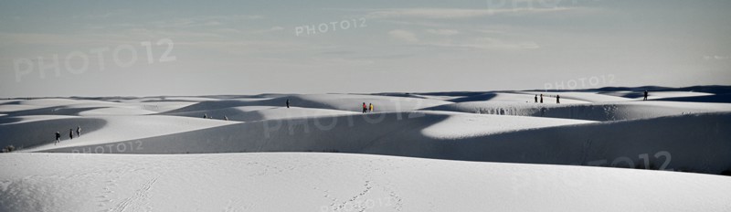 USA, New Mexico, Otero County, White Sands National Monunment. Landscape of white sand dunes with distant figures. 
Photo : Hugh Rooney