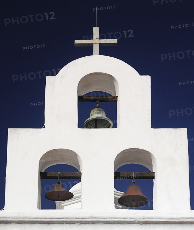 USA, Arizona, Tucson, Mission Church of San Xavier del Bac. White painted bell tower with three bells and topped with a cross. 
Photo : Hugh Rooney