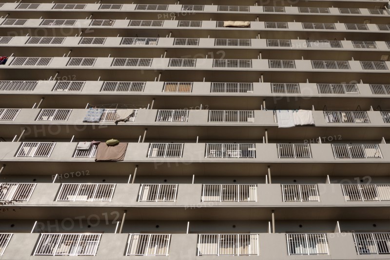 Japan, Honshu, Tokyo, Exterior or an apartment block with futon mattresses hung over balcony rails to dry. 
Photo : Jon Burbank