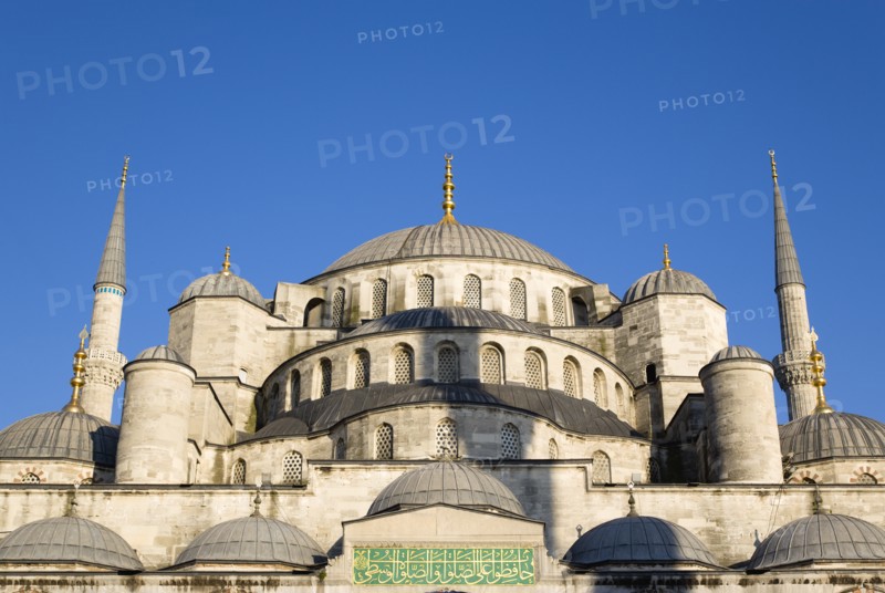 Turkey, Istanbul, Sultanahmet Camii The Blue Mosque domes seen from the Courtyard with Arabic text from the Koran. 
Photo : Paul Seheult